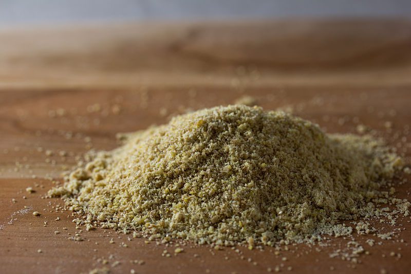 Ground flaxseed in a pile on a wooden background